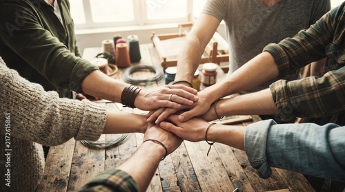 Teamwork hands stacked together in creative artisan workshop