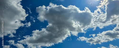 Фотография Blue sky with white cumulus clouds on a sunny day