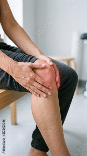 Person Holding Painful Knee During Home Recovery
