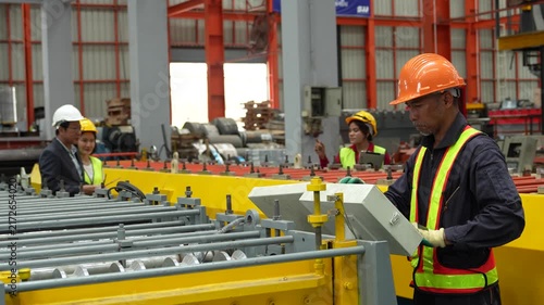 Engineers and staff are inspecting the assembly line system in a metal sheet and metal roofing manufacturing plant. (VDO 4K)	