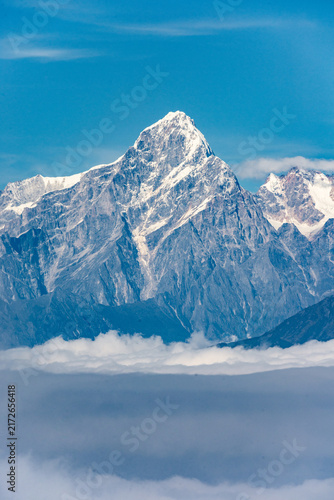 Panoramic views of snow-covered mountain peaks rising above a spectacular sea of clouds under clear blue skies, seen from Niubei Mountain in Sichuan, China