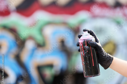 Quadro su tela Street art and urban creativity, person holding a spray paint can with black glo