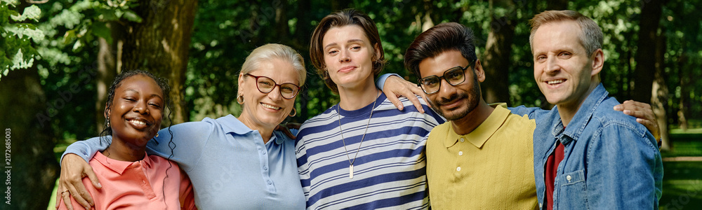 Obraz premium Portrait of diverse multiethnic group smiling during outdoor psychotherapy session in park, representing mental wellbeing and community support, ideal for healthcare marketing, header