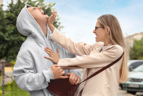 Cuadro en lienzo Conflict and aggression angry woman hitting a man in a public street domestic vi