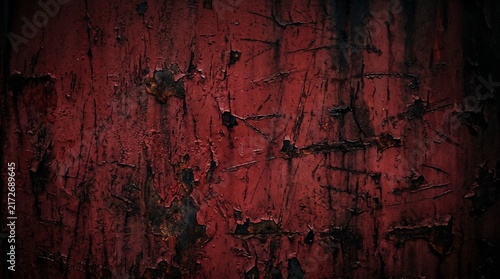 Close-up of weathered dark red painted surface with cracks and texture