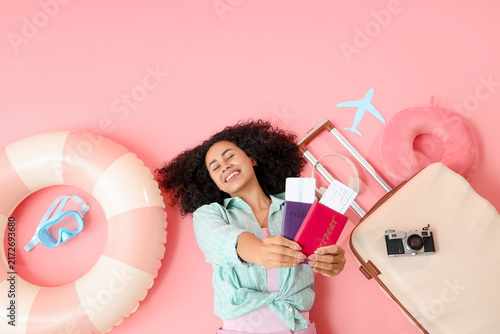 Young female African-American tourist with passports, tickets and travelling ...