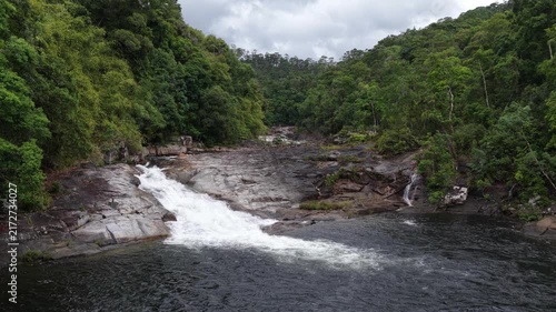 Low Aerial Drone Flight Along a Long Powerful Cascade in Chu Yang Sin National Park, Dak Lak, Vietnam, Showing White Rushing Water Flowing into a Deep Natural Pool Surrounded by Rocks