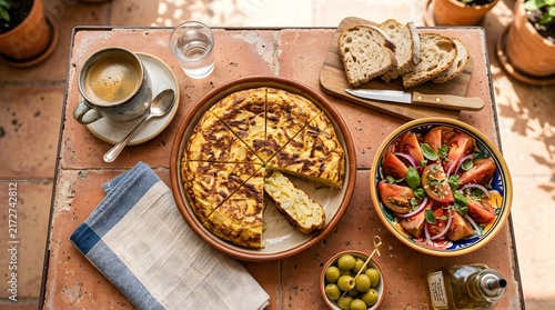 Overhead view of spanish omelet with salad coffee and bread on rustic table