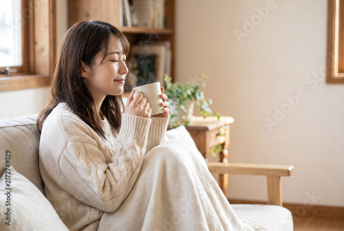 Naklejka 湯気の立つマグを両手で包み目を閉じる女性 冬のあたたかいひと息