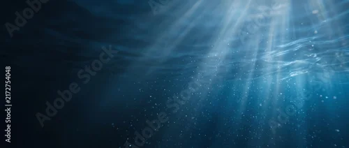 Panel kuchenny z motywem Underwater ocean background with sun rays piercing through deep blue sea water surface.