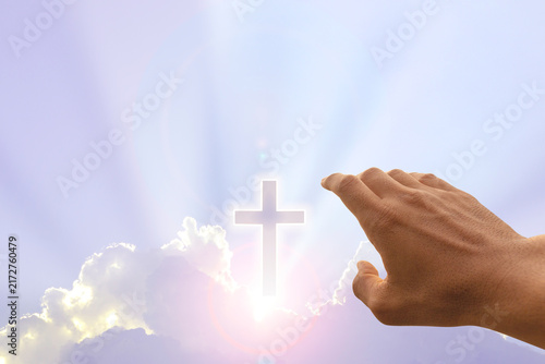 Hand and Cross on beautiful cloud at sunrise