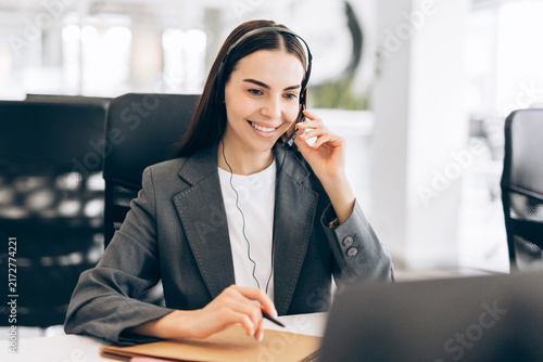 Bild auf Leinwand Customer support specialist wearing headset helping clients remotely