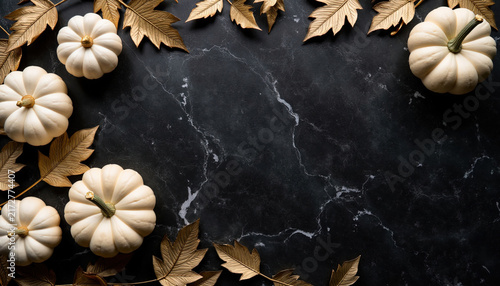 Luxury autumn frame flat lay with white mini pumpkins and golden maple leaves on black marble background with copy space