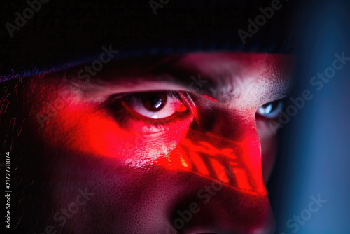 Macro Close Up of Hacker Eyes Illuminated by Red Light and Screen Projection
