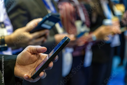 Hand Holding Smartphone at Business Exhibition