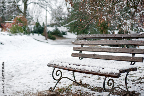 Bench in the winter park. rest in the city park. autumn season, nature, outdoor hiking. wooden bench in the snow closeup, resting place. cold winter season. first snow. the wooden bench is covered ice