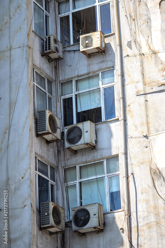 Old reinforced concrete apartment building. Apartment windows and air conditioning units. Urban living space. Istanbul's ghetto.