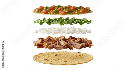 Exploded view of carnitas taco ingredients layered vertically on white background for food styling