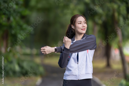 Fotografie Asian woman stretching before a workout in a public park to maintain a healthy lifestyle