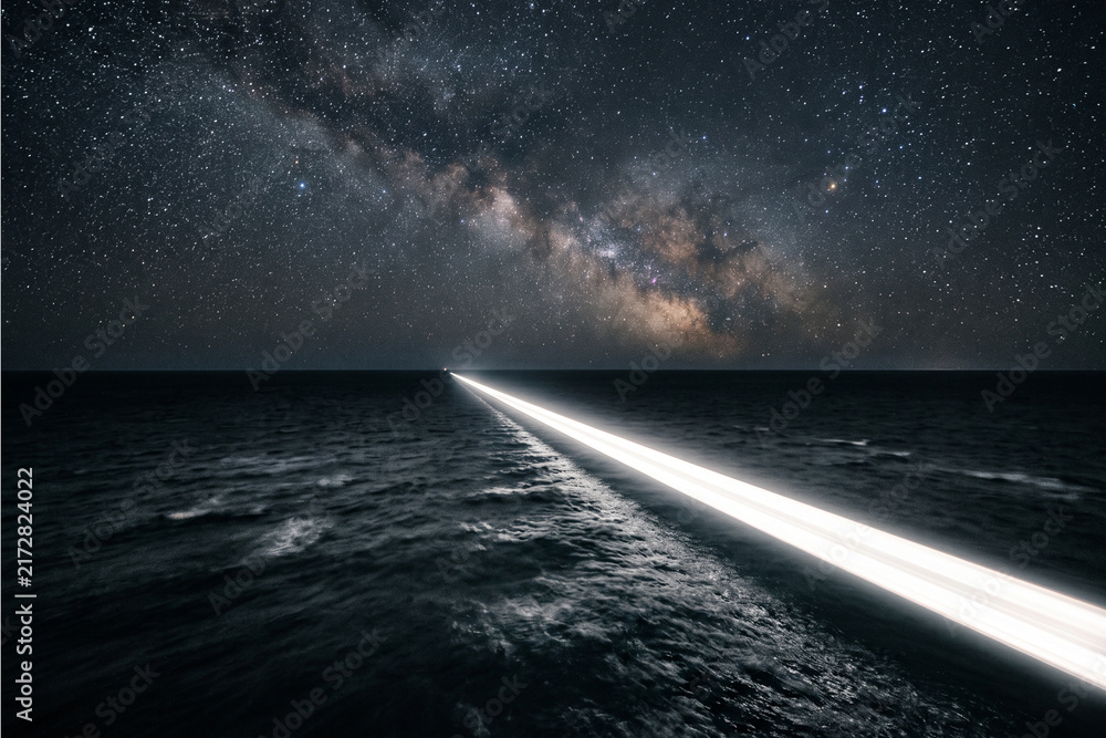 Fototapeta premium Illuminated pathway across ocean under starry night sky for astronomy education, night photography inspiration, and cosmic exploration themes