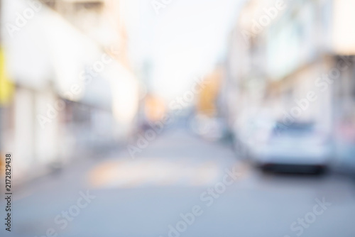 Abstract blurred urban local neighborhood street background with white buildings and a parked car