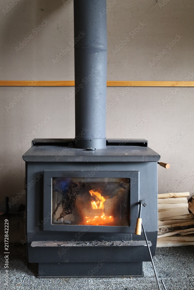 Naklejka premium Cozy fire burning in a black wood stove