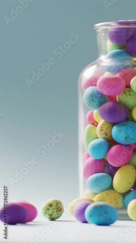 Animation of fingers with easter bunny and easter egg over jar of easter eggs on blue background