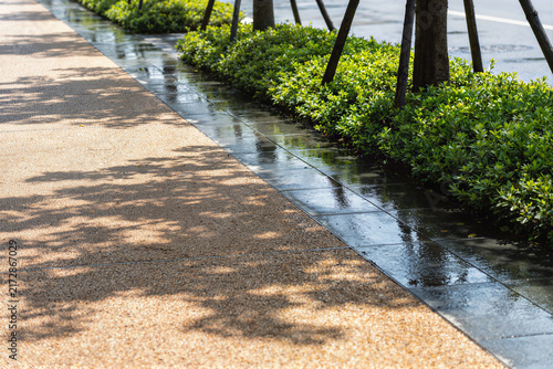 Urban riverside walkway with permeable paving and hedges