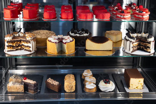 Variety of gourmet cakes and pastries in a bakery display case