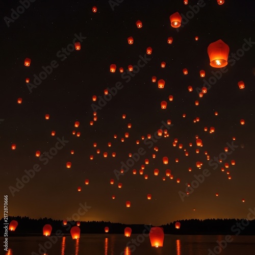 Floating Lanterns Illuminating Night Sky Over Water.