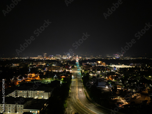 Night aerial view of cityscape with roads, buildings, and distant lights