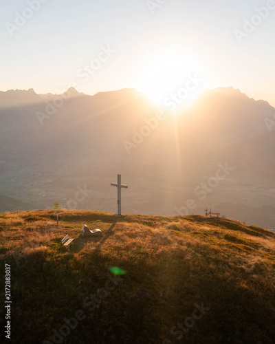 Majestic alpine mountain peaks illuminated by warm golden sunrise light, creating a breathtaking summer landscape in the Austrian Alps, perfect for travel, tourism and premium nature imagery.