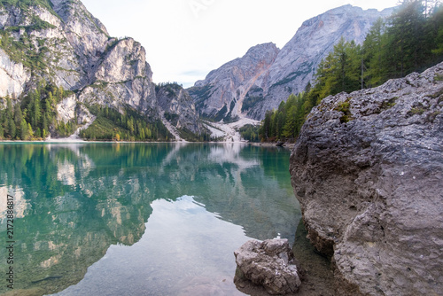 Quadro su tela Crystal Clear Alpine Lake with Turquoise Water Reflecting Rocky Mountain Peaks a