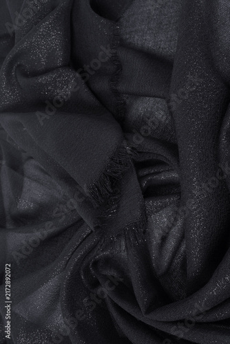 Texture of draped black fabric with metal threads
