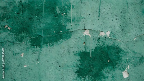 Distressed green concrete wall texture with peeling paint and weathered grunge surface.