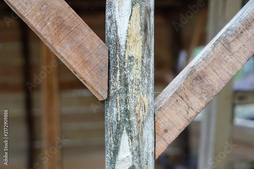 Close-up shot of a wooden pillar construction with diagonal support beam joint for structural support.