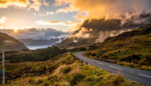 Scenic Mountain Road Under a Dramatic Cloudy Sky, Empty Asphalt Highway Through a Rugged Valley and Desert Landscape, Travel and Adventure Journey Concept