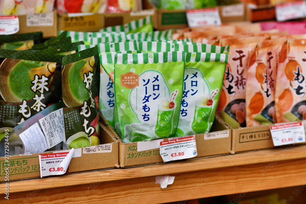 Obraz premium Düsseldorf, Germany - June 9th 2026: Melon Soda Mochi stand pack displayed in Asian supermarket, soft Japanese rice cake candy flavored with melon soda as a colorful modern confectionery snack