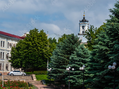 View of central Chernivtsi with green trees and a church tower in the background on a sunny day