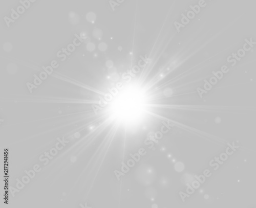 A radiant white light bursts from the center, scattering sharp beams and small glowing particles in various directions. The intense luminosity illuminates circular bokeh effects around it.