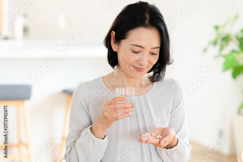 薬を服用する女性　中高年　ミドル世代