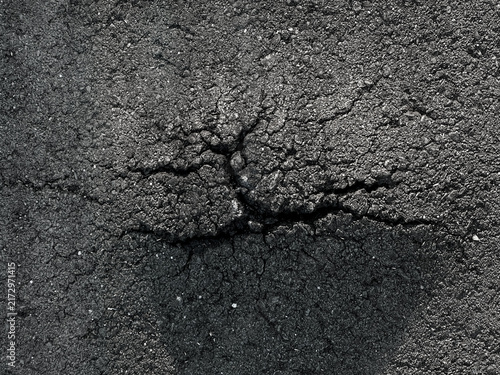 Obraz na plátně Close up top down view of dark cracked asphalt texture showing road damage and u