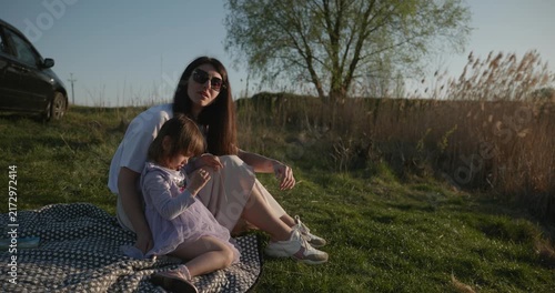 Family rest near Lake. Young mother spend time with children son and daughter enjoying nature. 4K 10-bit