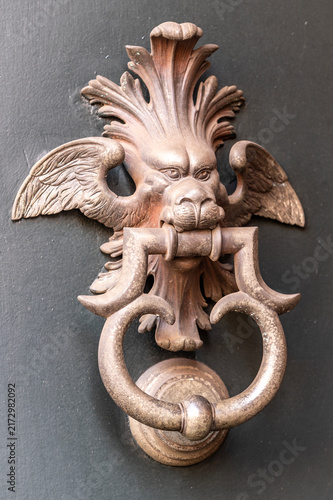 Obraz na płótnie Decorative metal door knocker with winged lion head and ring on a historic doorw