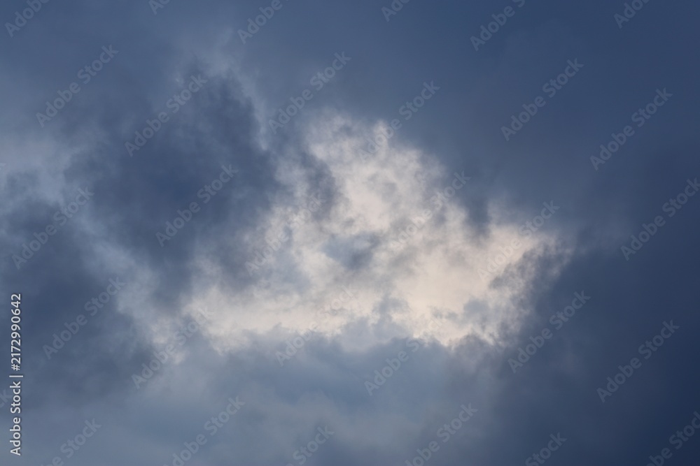Obraz premium Soft warm light breaking through center of dark storm clouds
