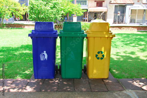 Three colorful recycling trash bins placed in a public park