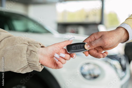 Hand passing car key to new owner