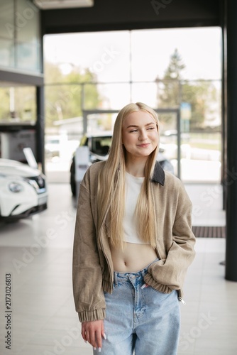 Young woman planning future car purchase at dealership