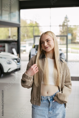 Young woman considering new car purchase in dealership