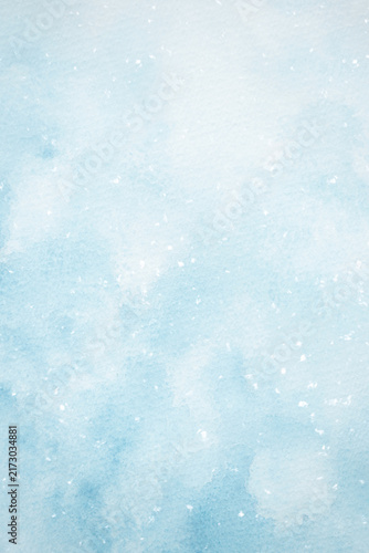 A blue watercolor background with falling snow for designing winter holiday web banners